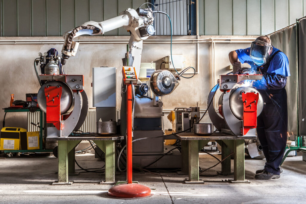 Man,And,Robotic,Machine,Work,Together,Inside,Industrial,Building