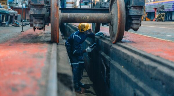 Rail,Maintenance,Technician,Use,Flashlight,To,Examine,Wheel,Assembly,Of