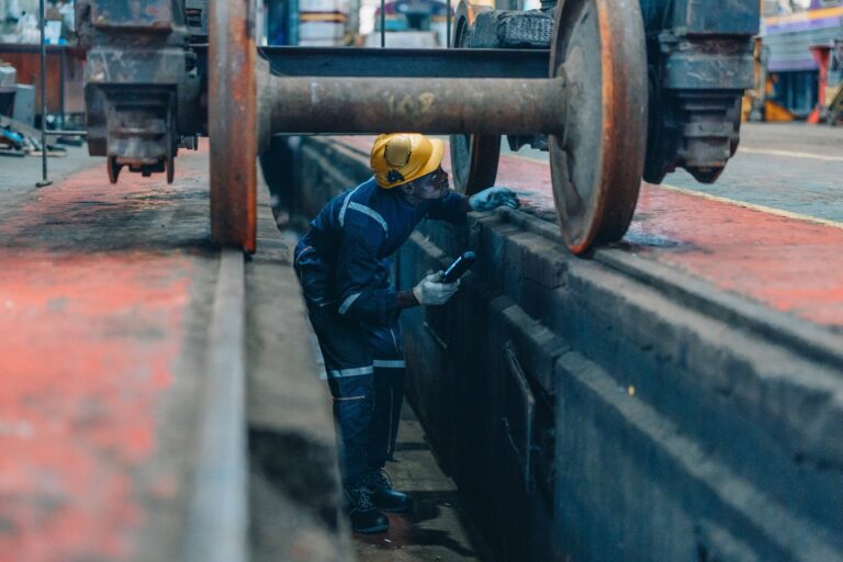 Rail,Maintenance,Technician,Use,Flashlight,To,Examine,Wheel,Assembly,Of