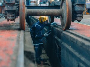 railway Worker inspecting train wheels in a railway maintenance pit